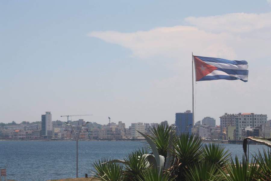 During mid-day, the Cuban flag waves in the wind by the harbor overlooking Havana, Cuba.