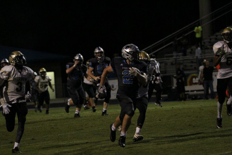 Junior running back Cole Gilley speeds past multiple Mustang defenders. Gilley set two new school records in a 49-0 rout of Morrow.