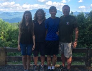 The Kelly family pose for a family photo while visiting Gatlinburg, Tennessee, for the first time.  The parents do their best to share the housework equally and support gender equality in the household.