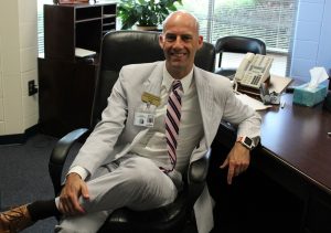 Principal Allen Leonard poses for a photo in his office. “I’m always prepared and excited for the school year to start so I can improve each year at my job,” Leonard said. This will be Leonard’s sophomore year as principal.