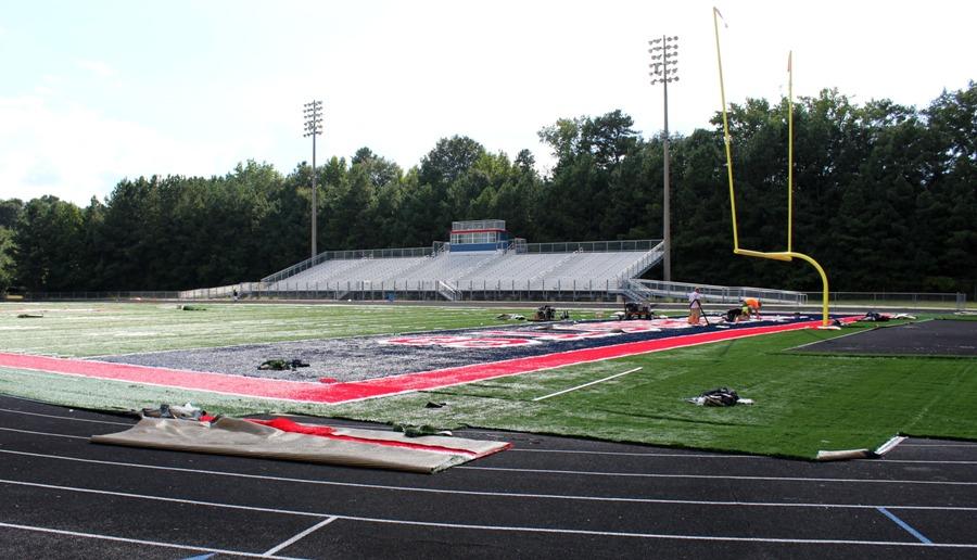 Volunteers repaint Sandy Creek’s field before the Patriots’ next home game. Sandy Creek is the first high school in Fayette County to have its own synthetic turf field. Their success with the synthetic turf will determine if the countywide project will continue in the future.
