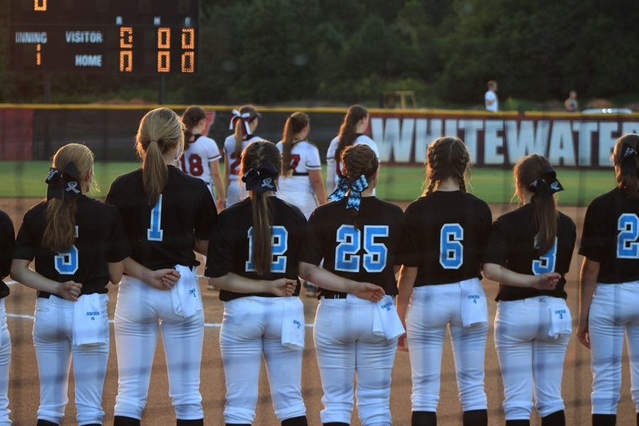 The+Lady+Panther+varsity+softball+team+lines+up+on+the+first+base+foul+line+for+the+National+Anthem.+The+Panthers+were+defeated+by+the+Whitewater+Wildcats+8-3+on+Tuesday+night.