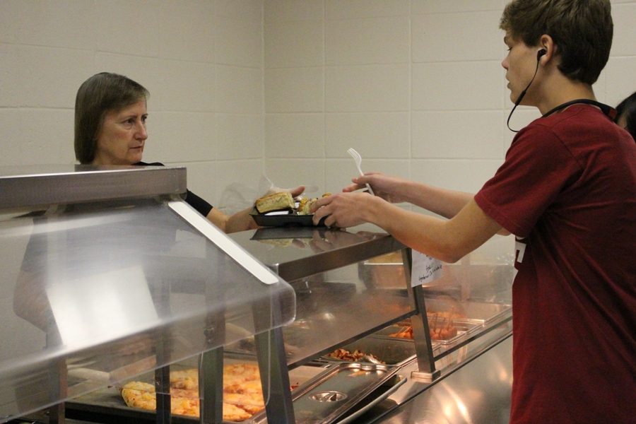 Margaret McClain serves a student lunch. “We love seeing the students. That’s the favorite part of our day, when we get to see them and when we make them happy by serving them what they want,” lunchroom manager Maureen Hankey said.