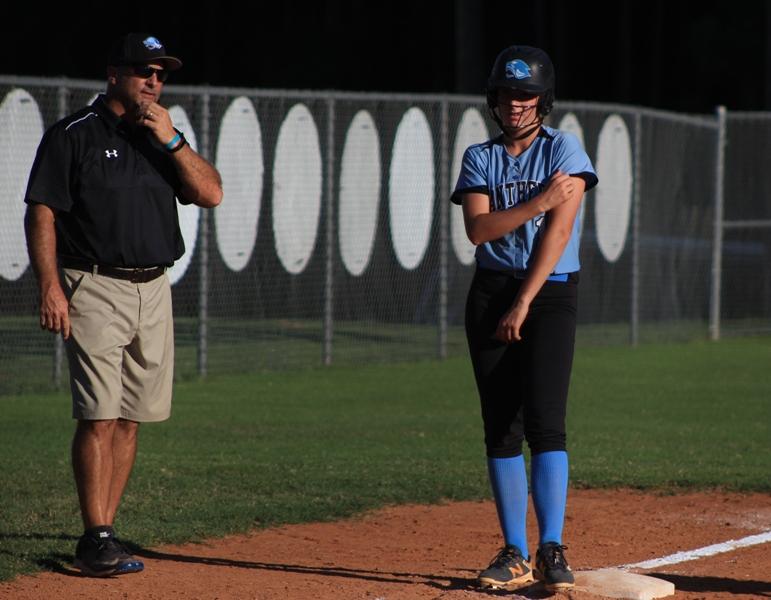 Coach Mark Williamson gives advice to one of his players on third base. Due to the mercy rule, the game ended in the third inning. Sophomore Makaela Sigler led the team with three RBIs. 