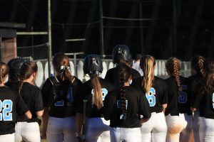 The Lady Panthers crowd home plate to celebrate one of four home runs of the night. Senior Shelby Daniel hit three home runs in the double-header against Veterans High School on Oct. 12. 