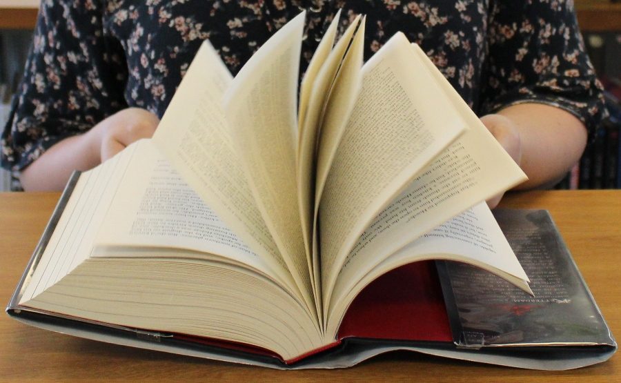 Starr’s Mill High School student quickly flips through the thrilling adventure novel “Six of Crows” by Leigh Bardugo. The sequel to to this book “Crooked Kingdom” was published on Sept. 22, 2016. 