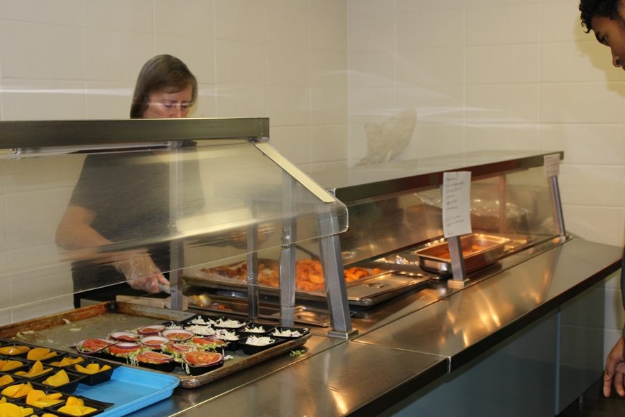 Member of the cafeteria staff serves a Starr’s Mill student lunch. The process to approve the lunch options on the menu take place at the federal, county, and school levels.