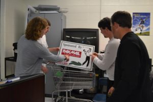 A group of entrepreneurship students organize sponsorship signs in preparation for the 12th annual PRISM golf tournament. PRISM uses four levels of sponsorship to help achieve its goal of raising $5,000.
