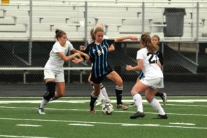 A Lady Panther dribbles the ball, but is attacked by three McIntosh players. Chief senior Taylor Malasek scored all three goals of the game within a four-minute span.