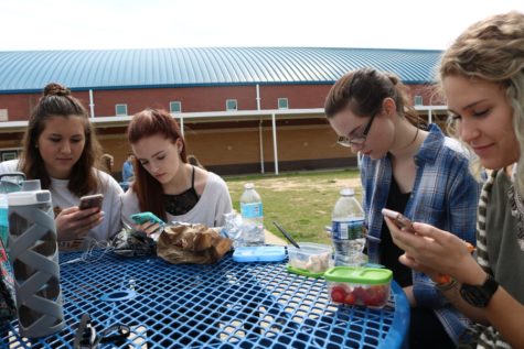 Students sit on the Starr’s Mill patio during C lunch. Although they sit together, this friend group and many others at Starr’s Mill pay no attention to each other or make conversation. Instead, each person is ensnared by their social media feeds. “Social media takes up time that is not easily made up. It takes away from school and friendships in some cases,” sophomore Blake Ryan said.