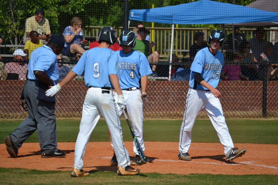 Senior Drew Pepper, junior Mitchell Sutton, and sophomore Brian Port celebrate at home after Pepper and Port scored from senior Will Evans’ two-RBI double. The Panthers scored six runs in the bottom of the sixth and went on to win 9-1 in game one against the Decatur Bulldogs.
