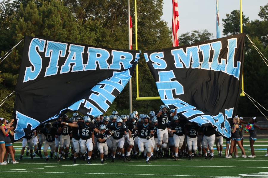 The Panthers run through the team banner before the game against Newnan. The game was played on the Panthers’ new turf field, and Starr’s Mill took home a 40-13 victory. 