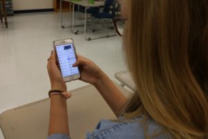 A student uses her phone to access her classwork. With the right apps, students can use their phones to benefit themselves in school.