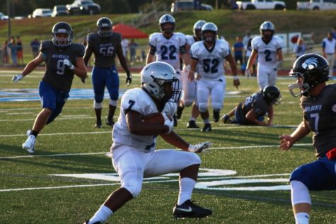 Senior Nick Brown jukes past a Wildcat defender on his way to the end zone. Brown rushed for two touchdowns during the scrimmage at Locust Grove.