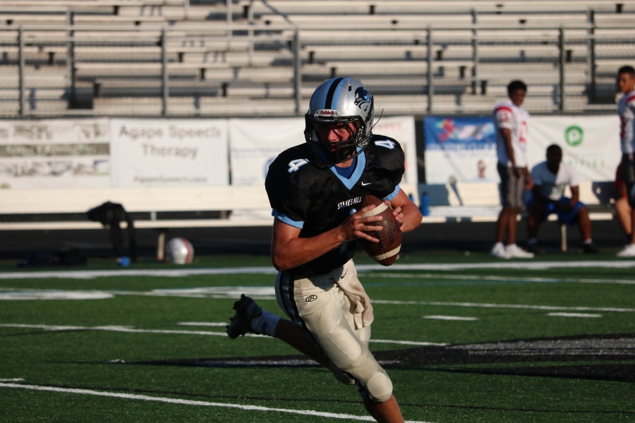 Sophomore quarterback Hunter Lawson breaks a tackle and throws for a 17-yard gain. Despite only scoring two touchdowns, the Panther offense put on quite a show against the visiting Patriots.