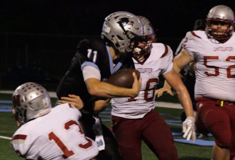 Senior quarterback Joey DeLuca is dragged down by a Wildcat defender. DeLuca completed three of his seven passes for 107 yards, while also rushing for 40 yards and a score.