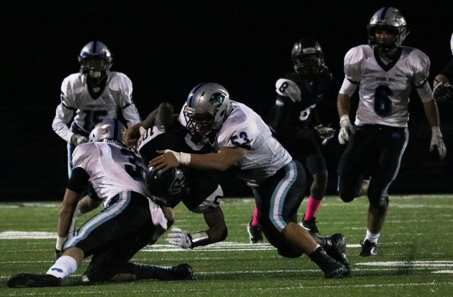 Two Panther defenders bring down a Riverdale player. The Panther defense gave up 366 yards, but forced two turnovers in their 37-19 win over the Raiders.