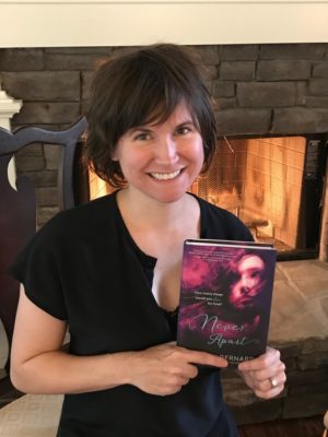 Local writer Romily Bernard holds her newest novel Never Apart.  The novel follows senior Grace Freeman as she Falls through different parallel universes where she watches her boyfriend die every five days.