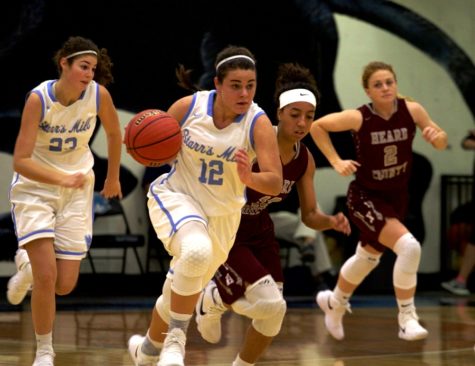 A junior player dribbles the ball up the court during a fast break. The Lady Panthers were able to score in transition due to spectacular rebounding.