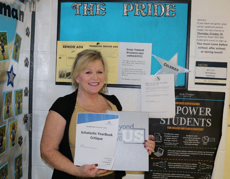 Yearbook adviser Patt Coleman proudly holds the gold medal for this year’s Scholastic Yearbook Critique award. This is one of multiple yearbook awards Starr’s Mill has won over the past six years. 