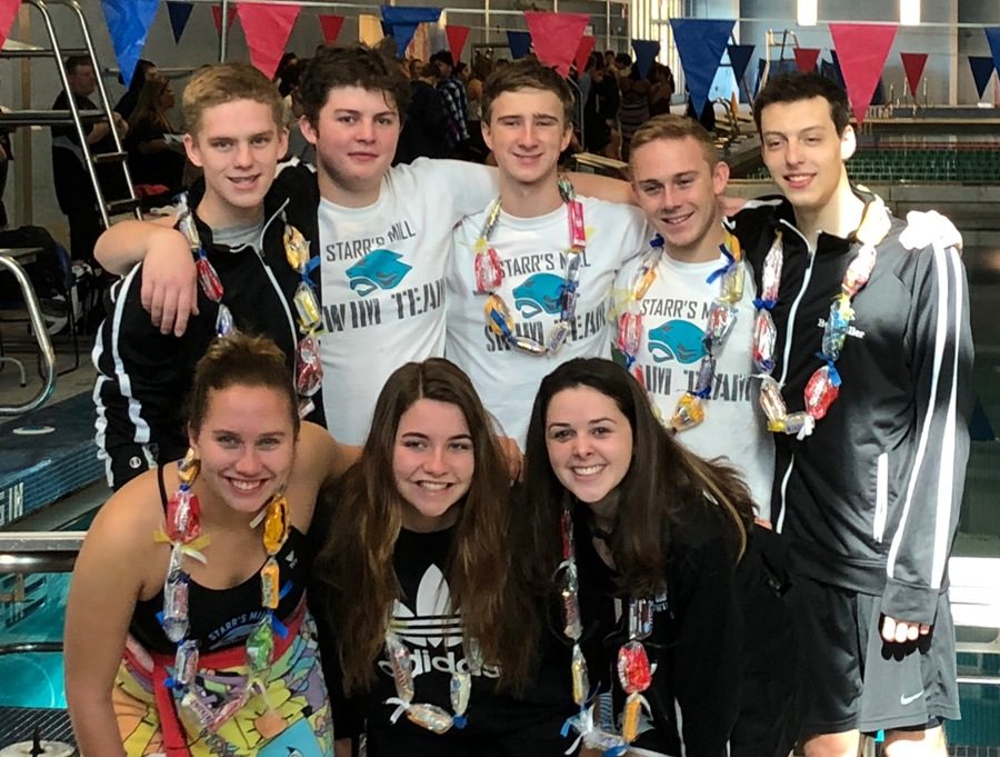 Eight county winner swimmers celebrate with candy necklaces after their historic win. The Starr's Mill varsity swim team has now won the county championship for the eighteenth year in a row, keeping their historic streak alive.