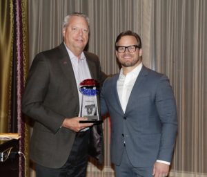 SMI President Marcus Smith (right) awards Ed Clark Promoter of the Year for Speedway Motorsports Inc. due to his hard work and drive to maintain Atlanta Motor Speedway as the best track every year. SMI owns and operates eight NASCAR-sanctioned race tracks around the country.