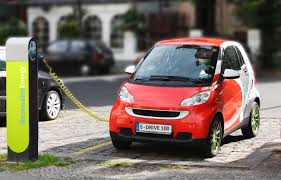 An electric car recharges at a charging station.  Tesla’s work with electric cars is revolutionizing the industry, making them more affordable.