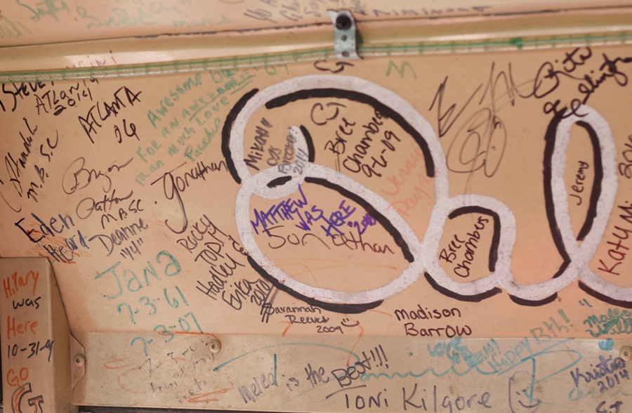 Signatures of race fans decorate the inside of the Oreo bus. The Oreo bus is a school bus that was converted into a “racing bus,” a bus designed to watch NASCAR races live in the infield.