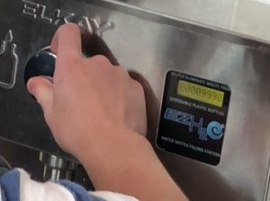 A student fills up the 9,999th water bottle at the station in the rotunda. Late Tuesday afternoon, students huddled around the fountain to see who would claim the 10,000th bottle filled.