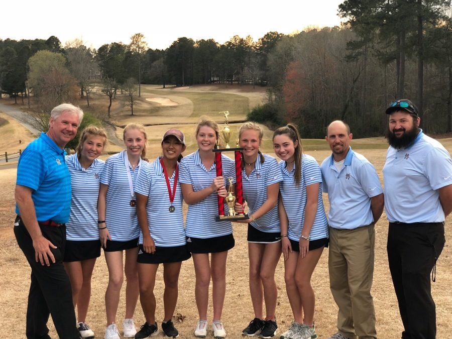 The team poses for a picture with their first place trophy. The team won by 10 strokes ahead of second place Ola High School.