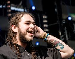 Post Malone looks at the crowd as he prepares to perform a song on stage. Post Malone released a new single, “Psycho,”  in February off of his new unreleased album. 