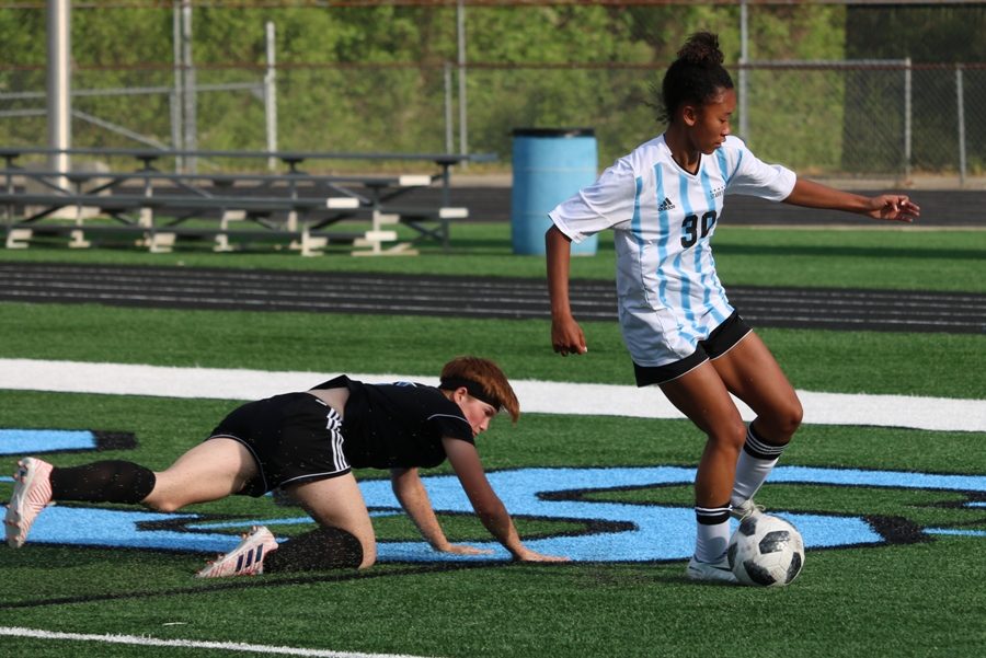 Lady Panther dribbles the ball while a Wildcat defender falls close behind her. The Mill defeated Locust Grove 3-0 in the first round of state playoffs. The game was slow in the first half, but after halftime, the team scored two goals in the first 10 minutes.