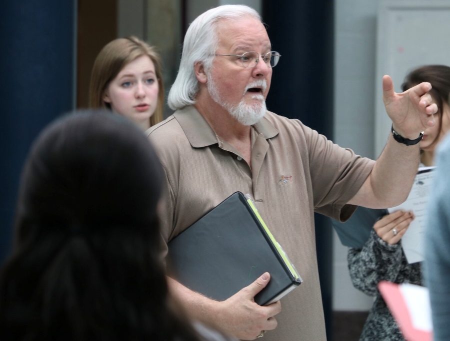 Dr. John Odom rehearses with his 7th period class in the rotunda. The band will perform its spring show on May 3, while various choral ensembles will perform on May 8. One aspect that makes the spring choral concert unique is that much of the show is student-created and student-conducted.