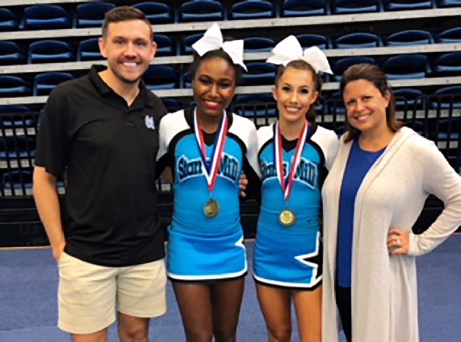 Coach Todd Saye (far left), varsity cheerleaders Tori Davis (middle left) and Hannah Defler (middle right), and head coach Heather McNally (far right) all gather together after the competition. Both girls advanced into the top 16. The winner of Cheerleader of the Year will be announced on Nov. 9.