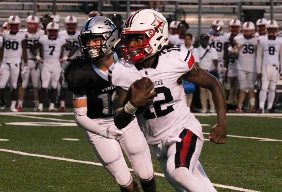 Junior quarterback Matthew Williams runs past senior safety Sean King. The Sandy Creek offense dominated, accumulating 555 total yards against Starr’s Mill.