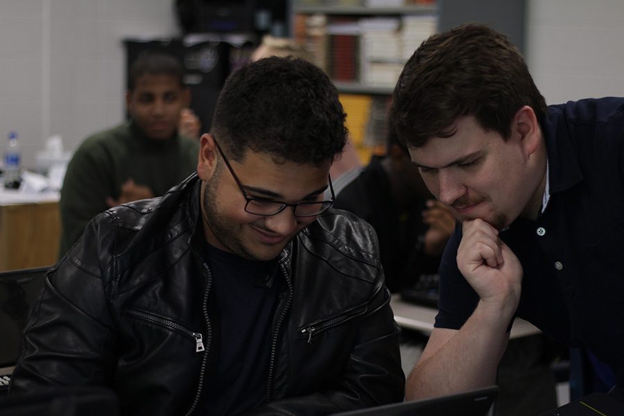 Terrence Fitzgerald (right) helps a student on an English assignment. “If my students don’t leave my English class feeling tired, I’m not doing something right,” Fitzgerald said.