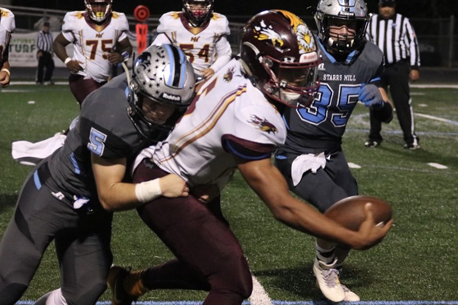 Senior quarterback Deyandre Ruffin reaches for a first down while being tackled by junior Panther Ardit Hoti. Ruffin totaled 190 total yards between the air and the ground, leading the Phoenix to an upset of Starr’s Mill 21-10. 