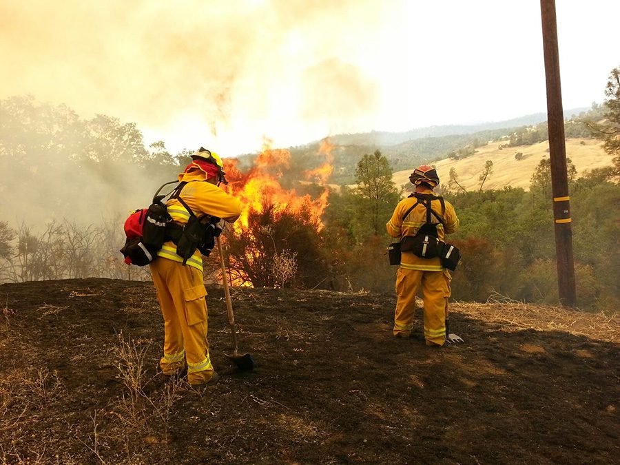 Firefighters work to put a fire during a blaze in northern California. Inmates who sign up to work alongside employed firefighters deserve equal treatment and a proper minimum wage. 