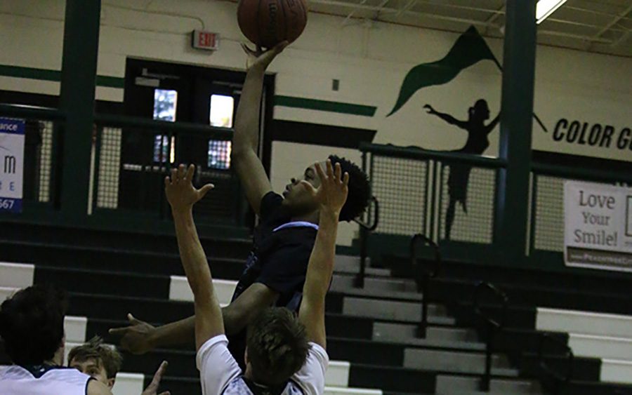 Sophomore Mike Townsend takes it to the hoop over two McIntosh defender. Townsend drew numerous fouls throughout the game en route to a Panther victory.