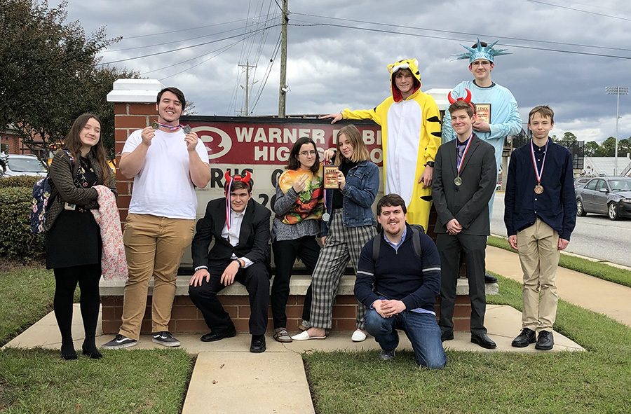 Speech and debate team members stand proud after competing. The team has added more meets to their schedule to get more bids to go to state and national meets. 