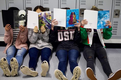 Several student’s take a look at several different volumes of MUSINGS, the school’s literary-art magazine. MUSINGS is currently accepting submissions for this year’s magazine. 