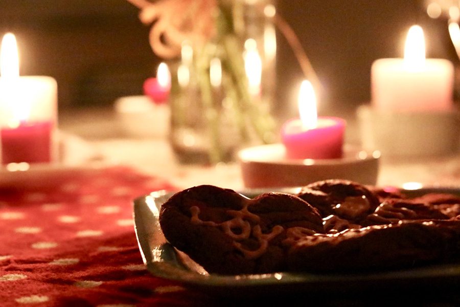 Feb. 14, 2019 - Valentine’s day cookies lay on a table along with candles and flowers. 