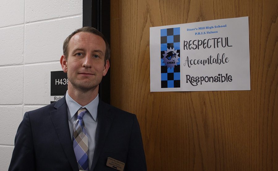 Assistant+principal+Scott+Robinson+pictured+next+to+one+of+the+PBIS+%28Positive+Behavioral+Interventions+%26+Support%29+posters.+For+Starr%E2%80%99s+Mill%2C+PBIS+will+really+be+about+emphasizing+what+our+school+culture+is+and+what+values+us+panthers+represent.