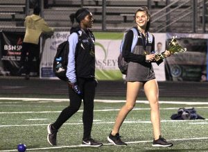 Senior Bree St. Julian and sophomore Allie Walker carry the first place trophy. Track and field competes again this weekend at the McEachern Invitational.