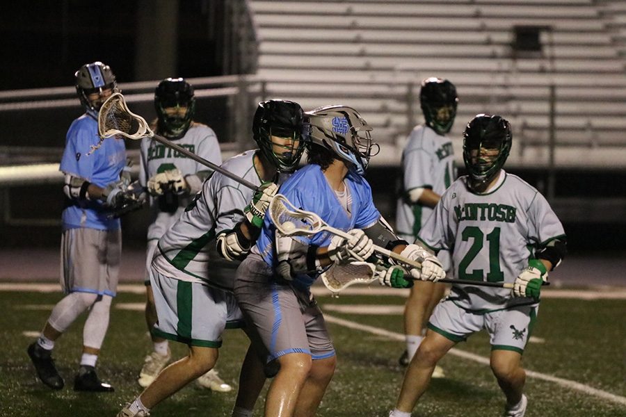 Panther player fends off a Chief defender while looking for a teammate to pass to. The Panthers balanced offensive attack proved to be too much for McIntosh, and the Mill defeated their rival 15-7. The win improved their record to 9-5 on the season. However, they lost the following two games, resulting in a 9-7 regular season record.