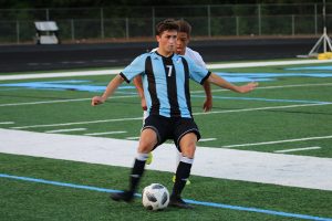 Senior Noah Pavel fights for possession against a Woodland defender. The Panthers kept the ball on their side of the field for the majority of the game, shutting out Woodland 4-0.