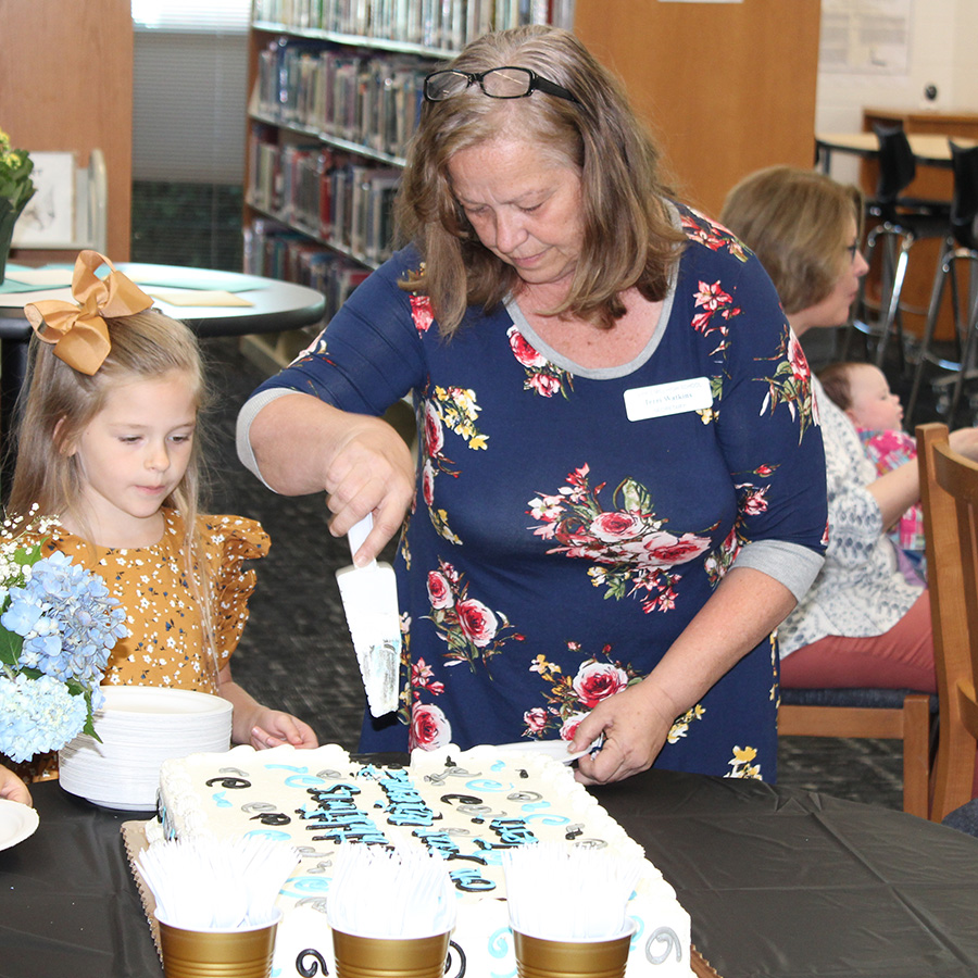 Athletic director secretary Terri Watkins cuts her retirement cake alongside one of her granddaughters. Watkins has been with Starr’s Mill High School since the day it first opened. Now, she’s getting ready to enter retirement and looks forward to spending more time with her kids and grandkids. 