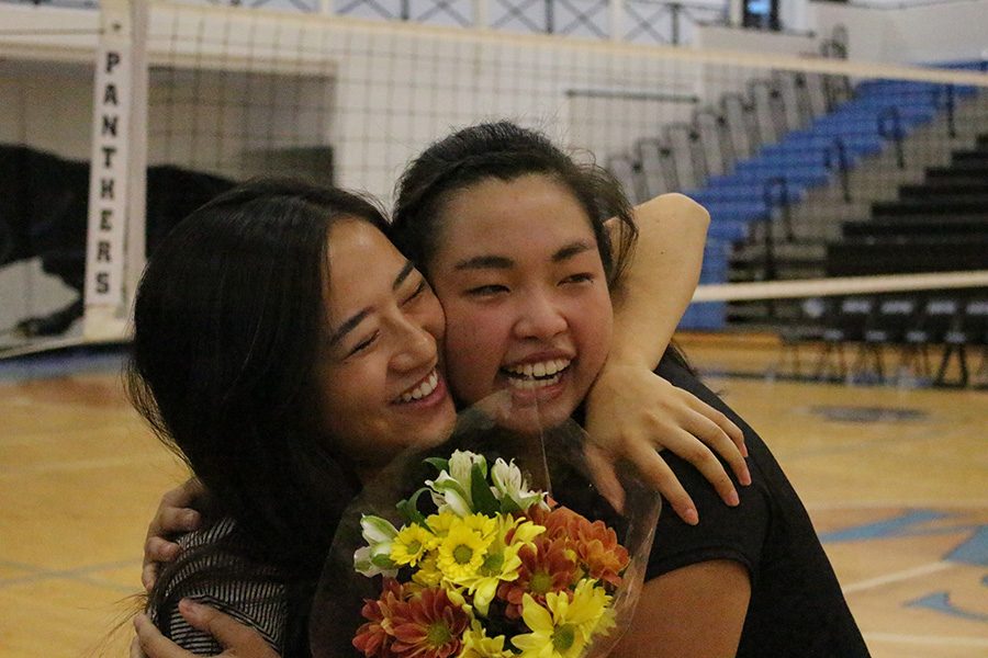 Senior Piper Dedrick hugs her friend after the game. The Lady Panthers won all three games against Ola and finished the regular season 30-9.