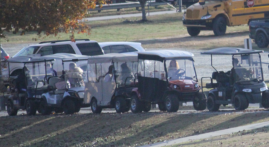 Golf+cart+drivers+look+back+in+line+as+they+leave+Starrs+Mill+to+see+one+cart+rear-ending+another.+The+frequent+accidents+involving+golf+carts+around+the+Mill+call+for+stricter+operating+regulations.