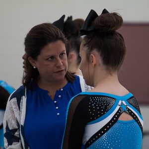 Competition cheer head coach Heather McNally instructs senior Hannah Defler before a competition in September 2018. McNally her resignation as the Starr’s Mill head cheerleading coach in order to spend more time with her son.